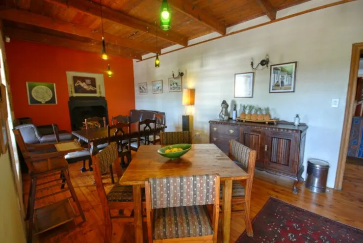 Wooden dining area with green pendant lights fireplace and various furniture