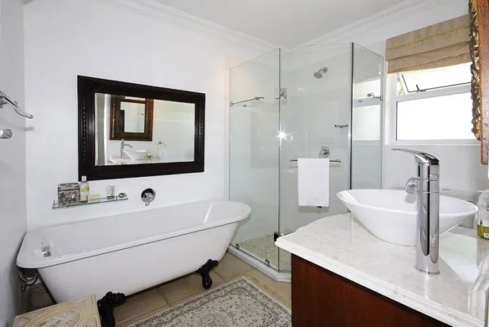Modern bathroom with bathtub walkin shower sink and large mirror