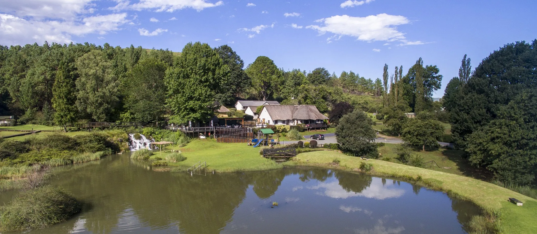 Countryside house by a pond with trees and greenery
