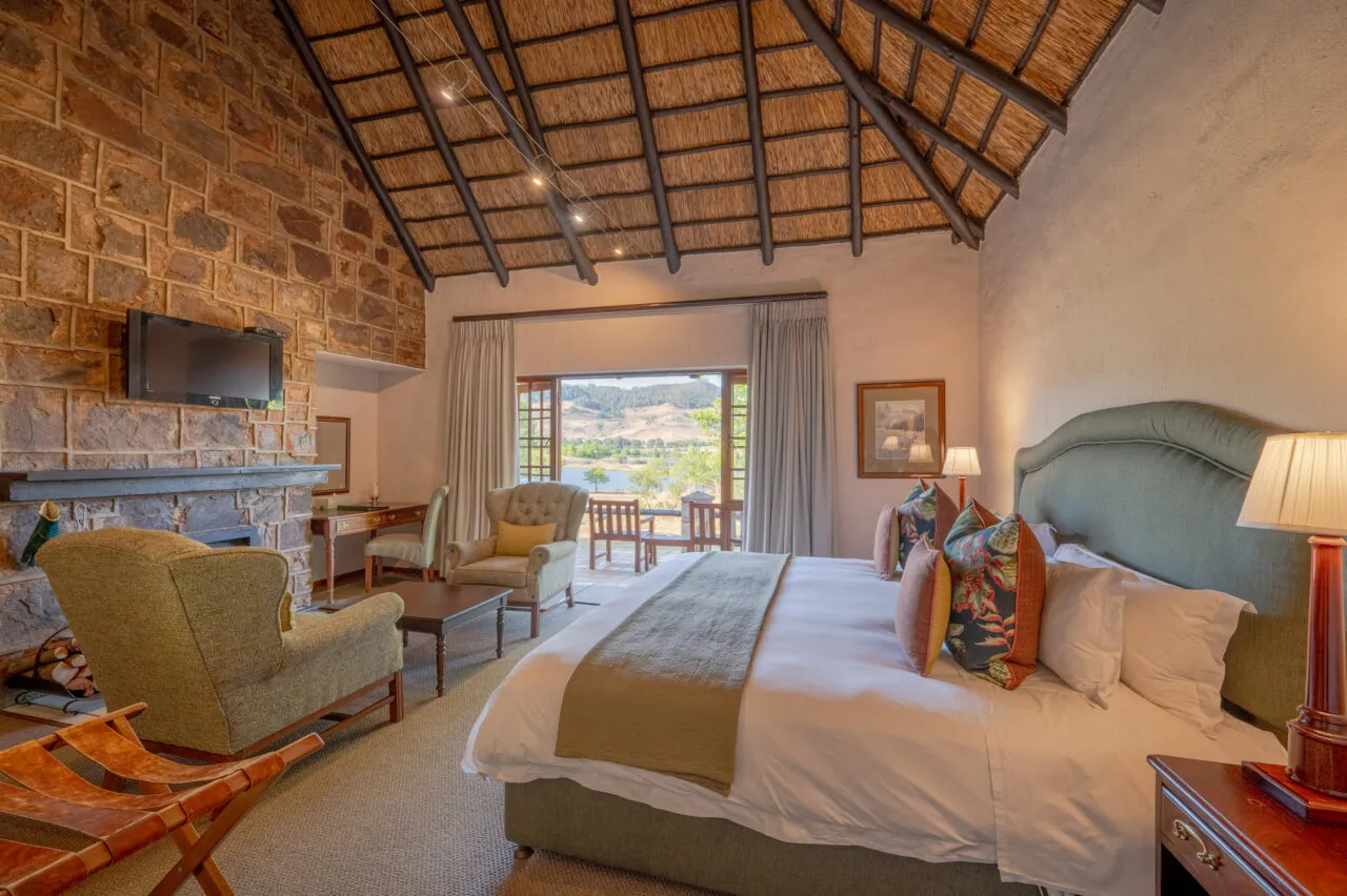 Cozy bedroom with fireplace large bed and scenic view through open doors