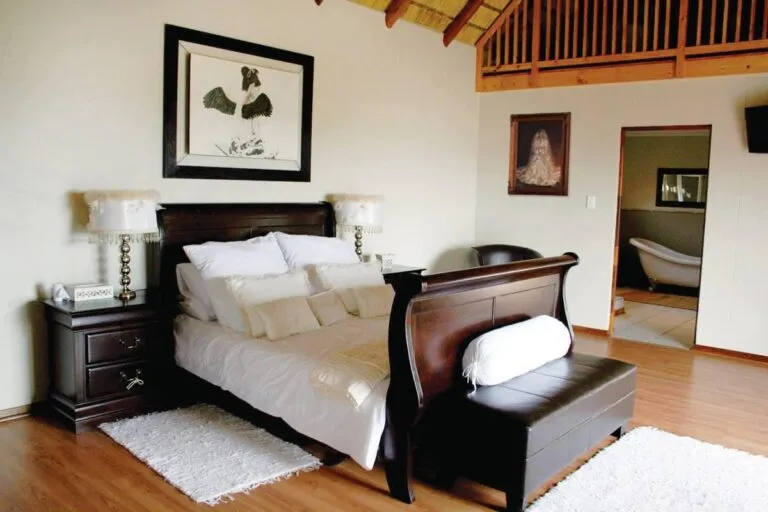 Bedroom with large bed wooden furniture and an attached bathroom
