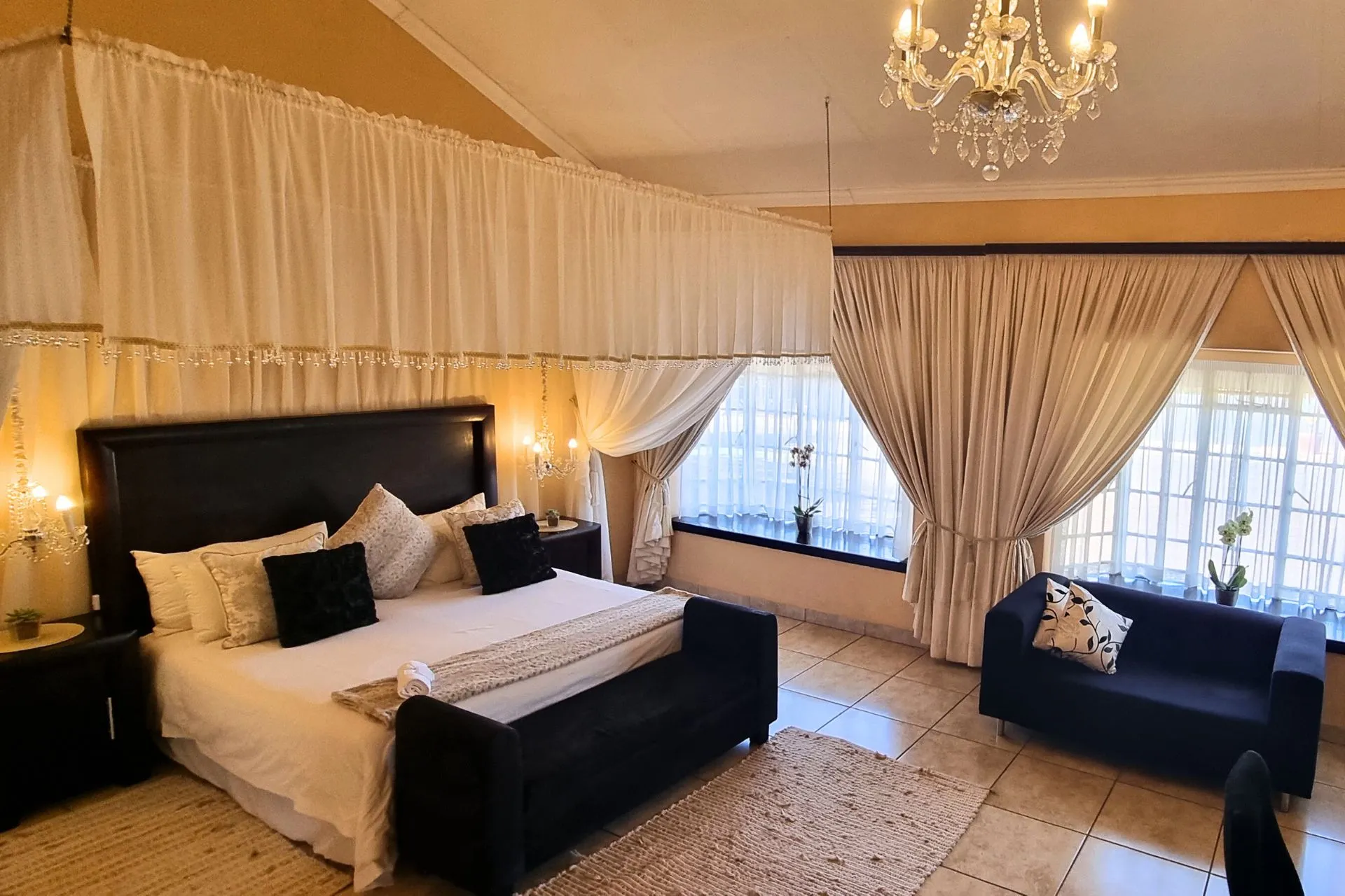 Large bedroom with a kingsize bed sofa and elegant decor