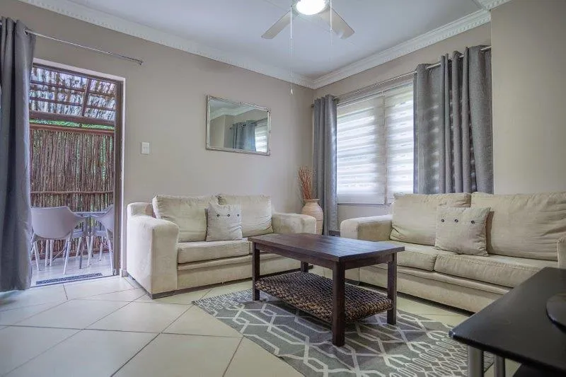 Beige living room with two sofas coffee table and large window