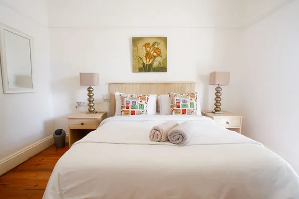 A neatly made bed with colorful pillows in a bright bedroom