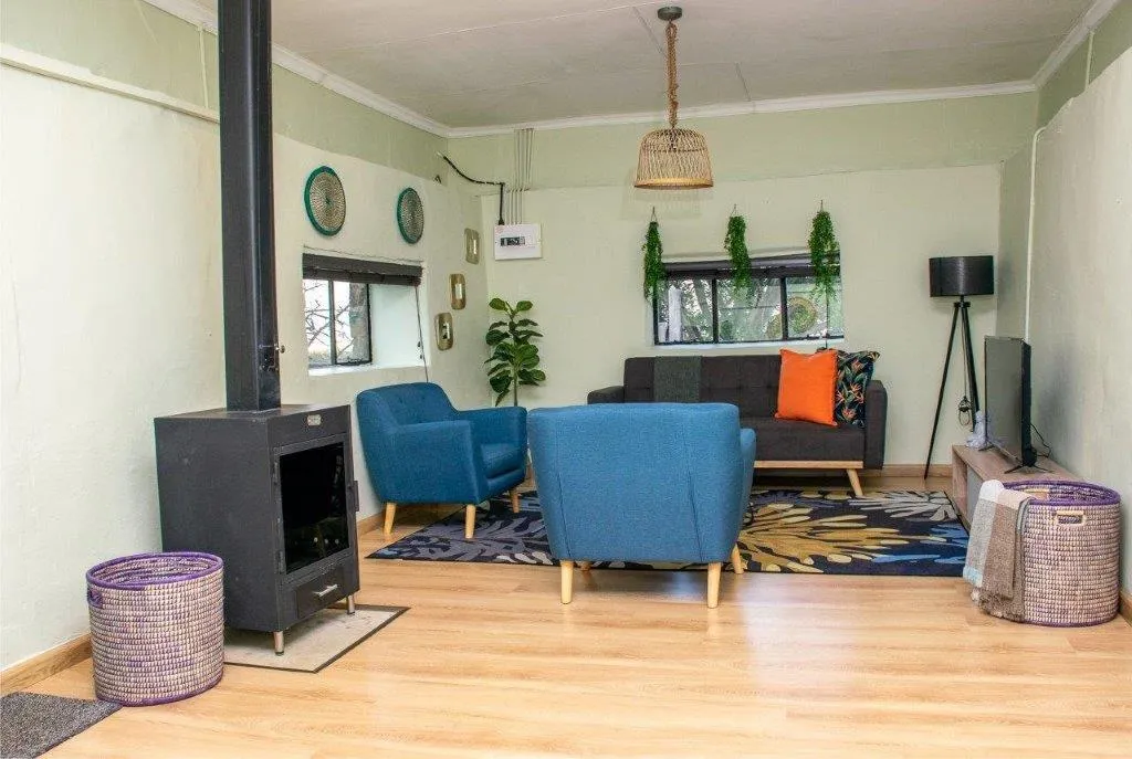 Cozy living room with blue chairs couch and a fireplace on wooden floor