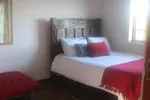 Bedroom with a large bed red pillows and a red throw blanket