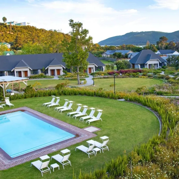 Resort with pool lounge chairs and scenic hillside view in the background