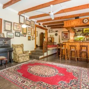 Cozy living room with piano seating and bar area wooden beams and rug