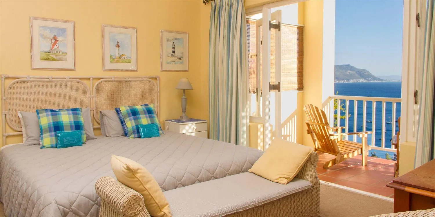 Bedroom with a sea view yellow walls and blue plaid pillows