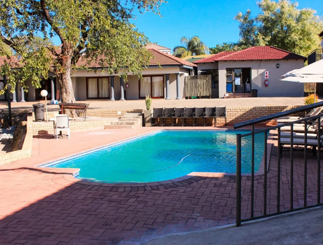 Swimming pool with lounge chairs and a building in the background