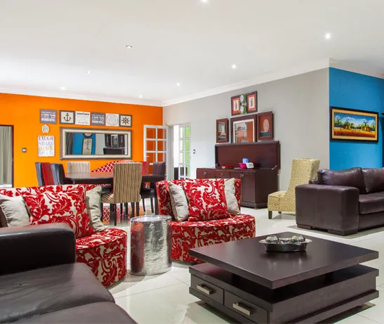 Bright living room with red and brown furniture eclectic decor and multiple seating areas