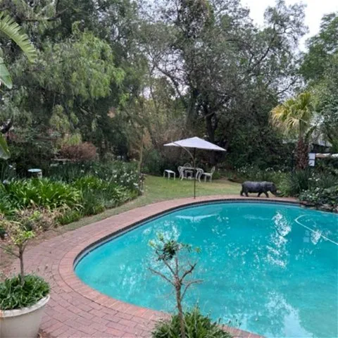 Swimming pool with statues in a lush garden setting