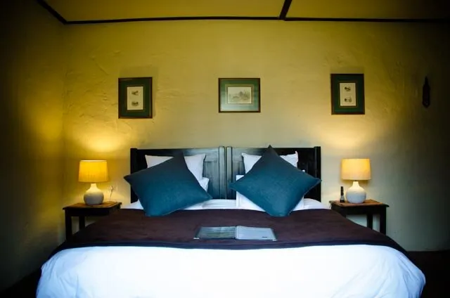 Cozy bedroom with a neatly made bed two bedside lamps and framed pictures