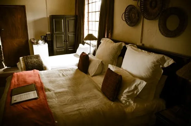 Cozy bedroom with a large bed pillows and woven wall decorations