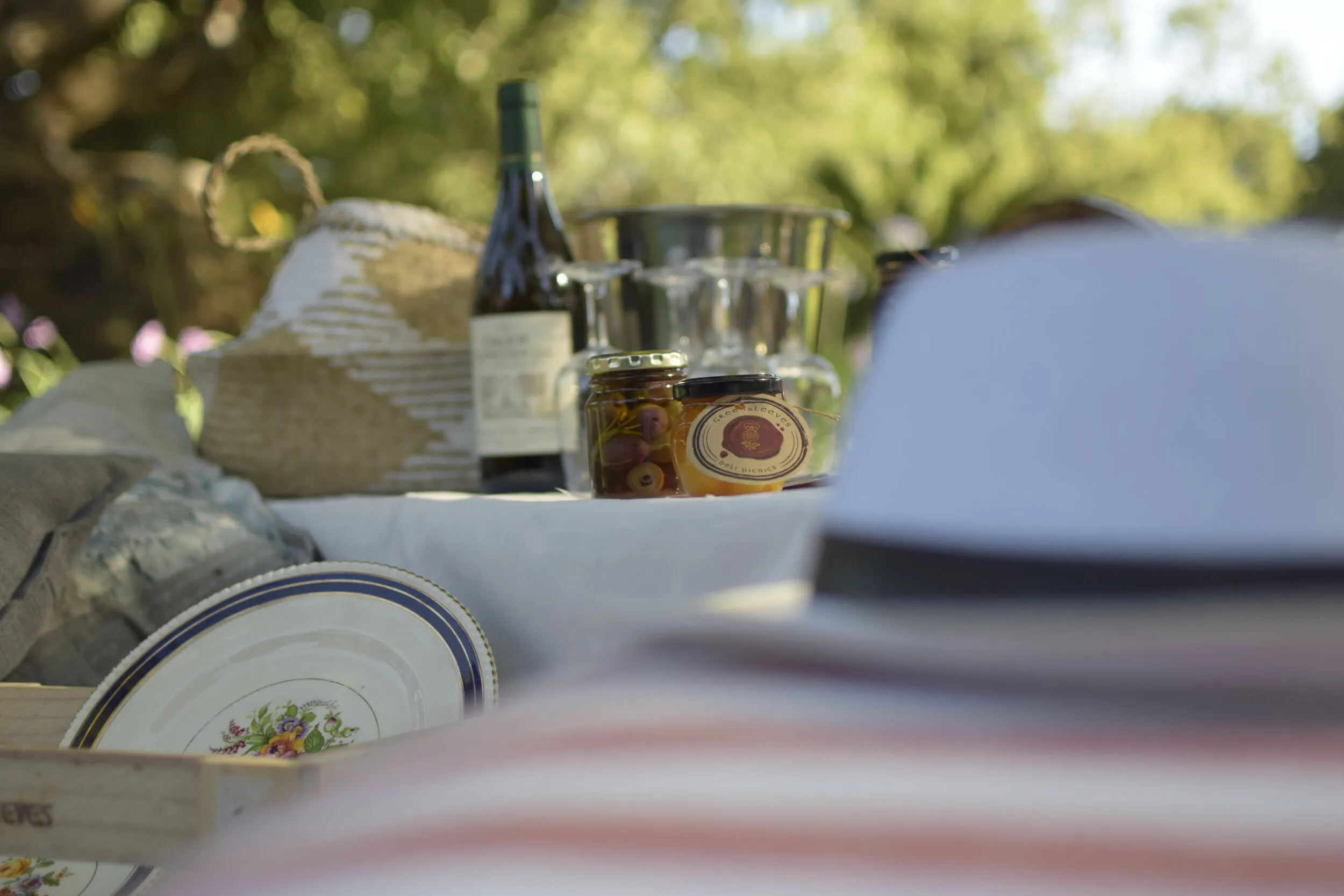 Picnic setup with wine jars and a plate in a garden setting
