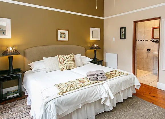 Cozy bedroom with a large bed bedside lamps and an adjacent bathroom