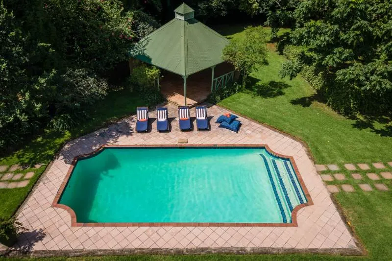 Aerial view of a swimming pool with lounge chairs and a gazebo