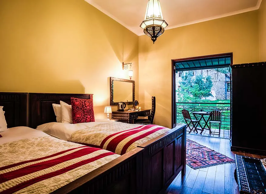 Cozy bedroom with two beds wooden furniture and a balcony view
