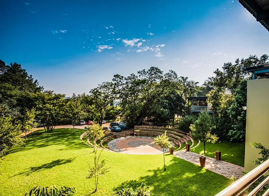 A circular stone seating area in a green park with trees and grass