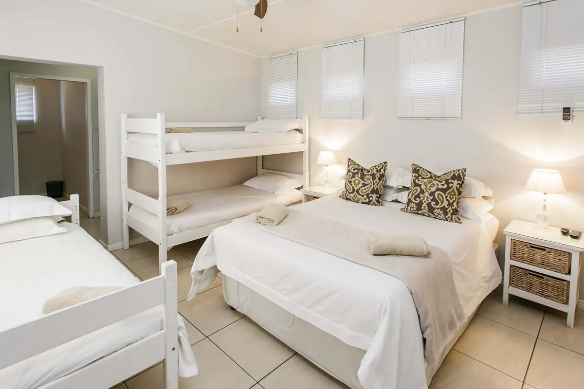 Bright bedroom with double bed bunk bed and bedside lamps
