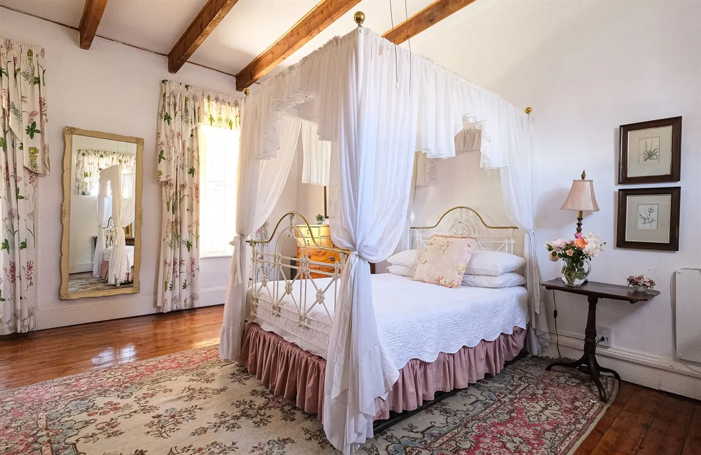 Elegant bedroom with a canopy bed floral decor and wooden floor