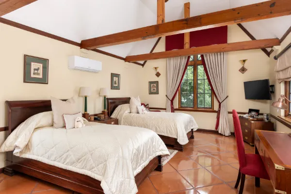 Cozy bedroom with two beds tiled floor and large window with curtains