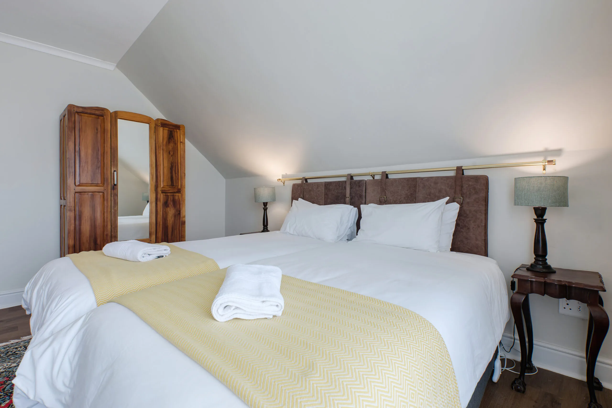Cozy bedroom with a large bed wooden wardrobe and bedside lamps