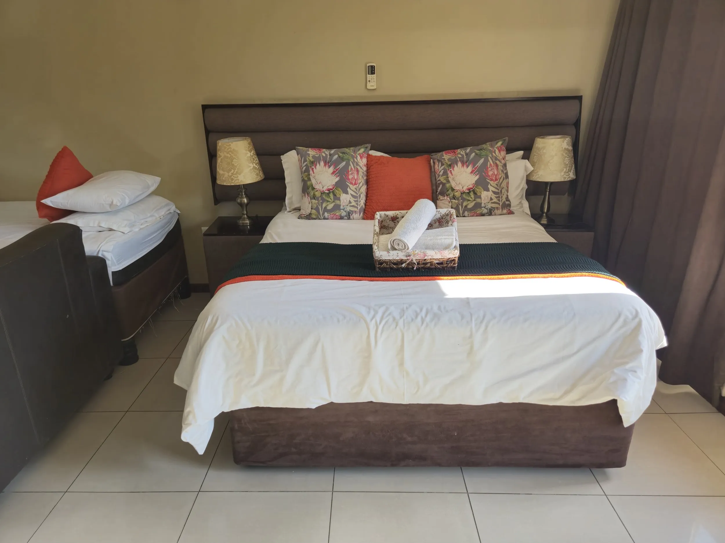 Bedroom with a large bed side tables lamps and a single bed