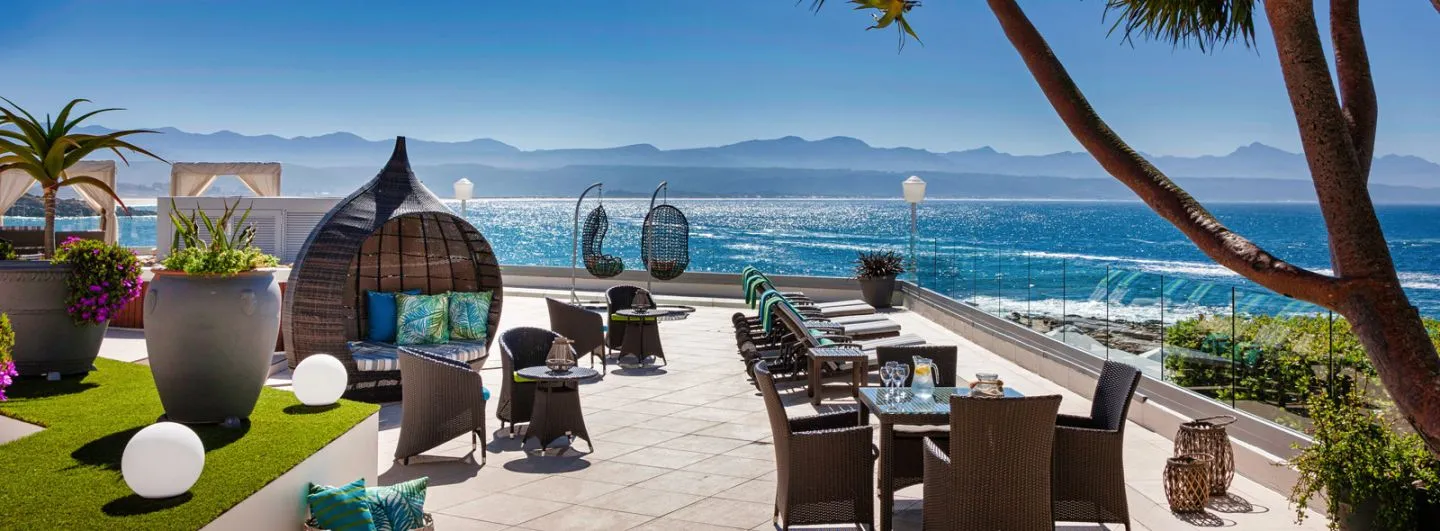 Outdoor seating area with ocean view palm trees and modern decor