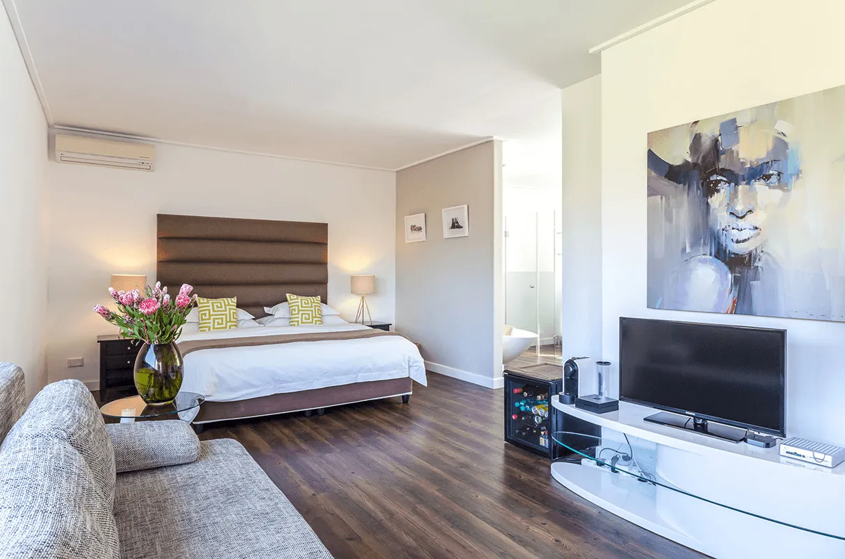Modern bedroom with bed sofa TV and abstract painting on the wall