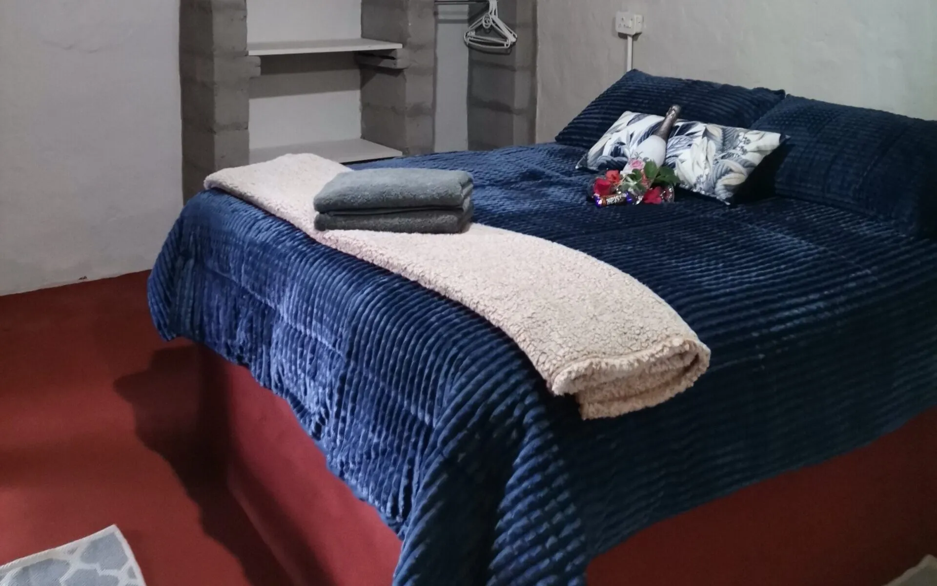 Cozy bedroom with a neatly made bed and a small shelf