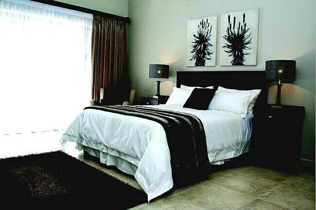 Modern bedroom with large bed black and white decor and natural light