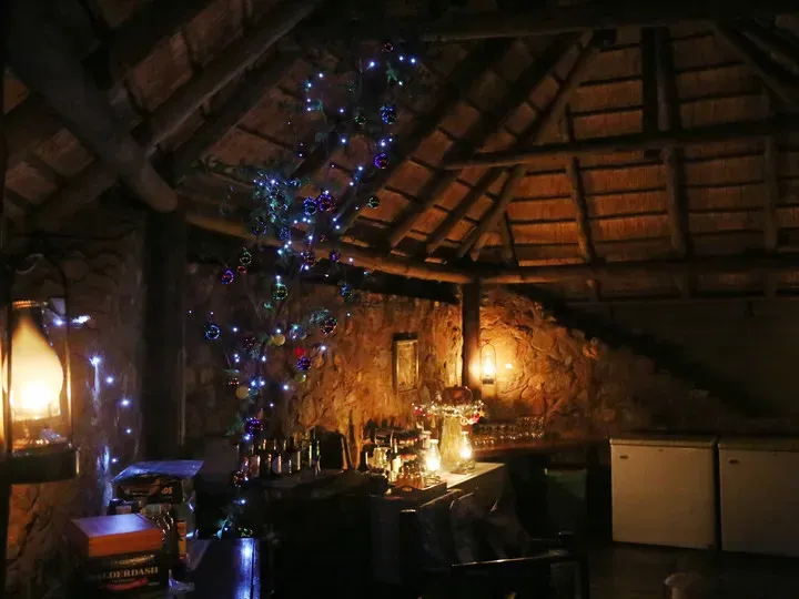 Cozy bar with stone walls wooden ceiling and festive lights inside