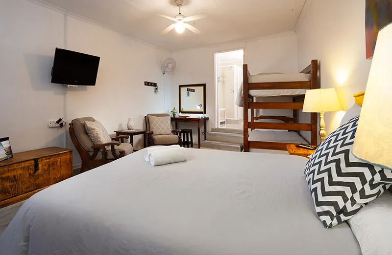 Cozy bedroom with bunk bed double bed TV chairs and lamps