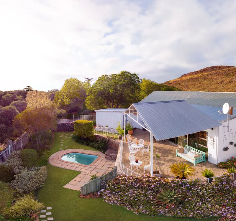 Aerial view of a house with a pool garden and patio furniture