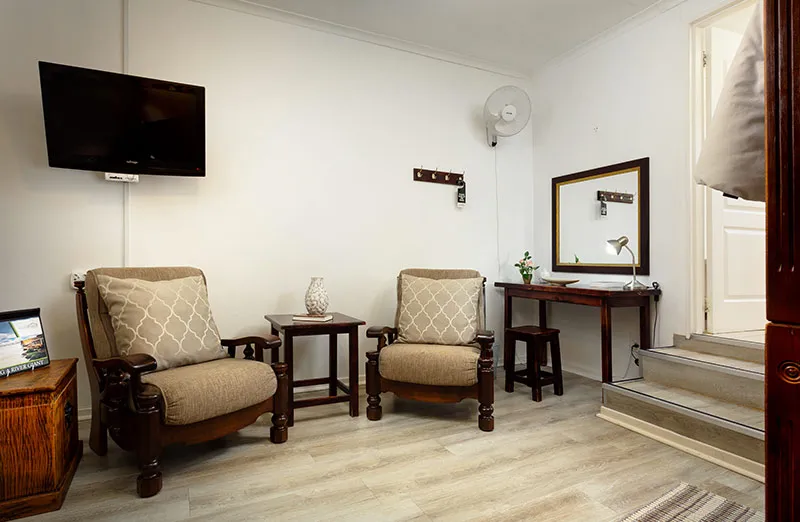 Two armchairs TV vanity table and mirror in a small room with steps