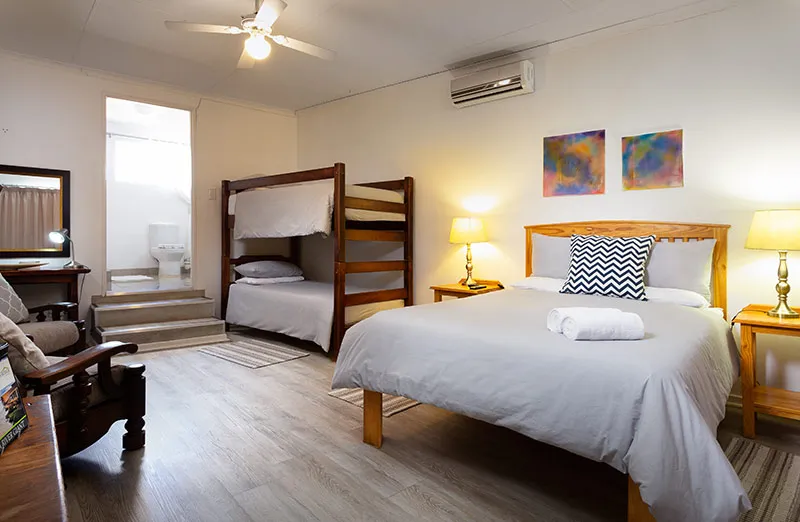 Bedroom with a double bed bunk bed wooden furniture and abstract wall art