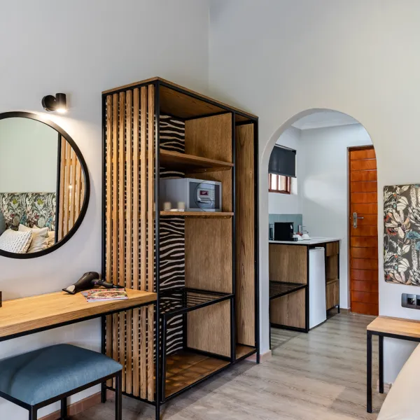 Wooden furniture in a modern room with arched doorway and artwork