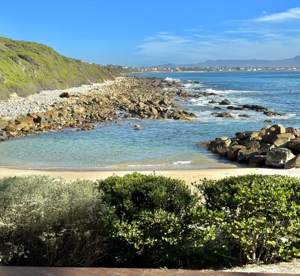Rocky coastline with a small sandy beach and clear blue water