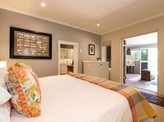 Cozy bedroom with colorful pillows ensuite bathroom and open door to patio