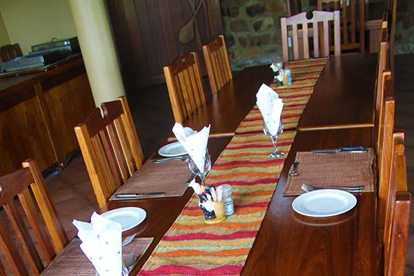 Wooden dining table set with plates napkins and condiments in a rustic room