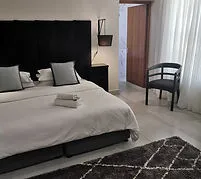 Modern bedroom with large bed chair and open door to bathroom