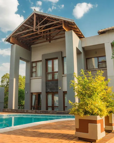 Modern house with pool large windows and potted plants in front