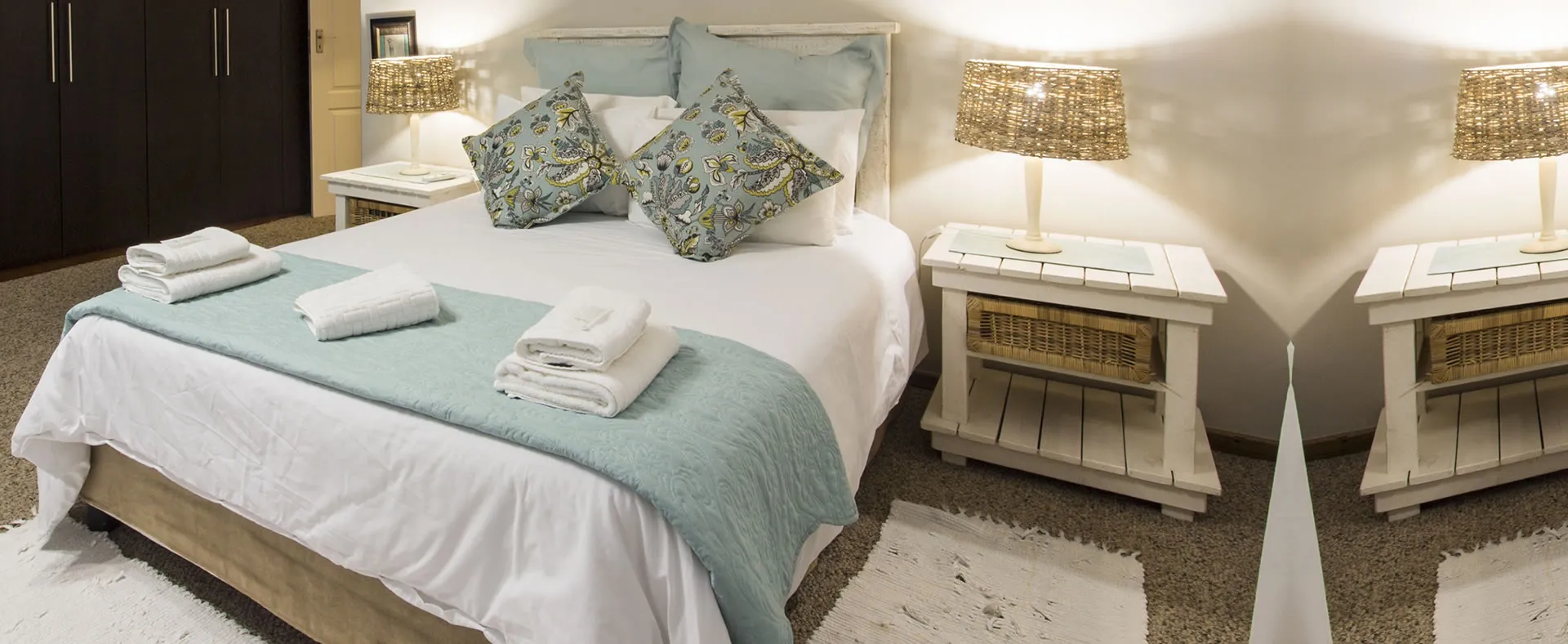 Cozy bedroom with a large bed nightstands and lamps on either side