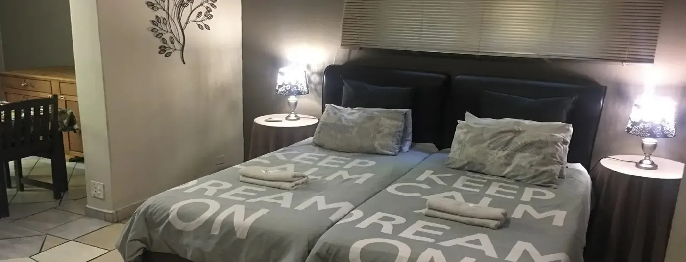 Twin beds with Keep Calm Dream On bedding in a cozy bedroom