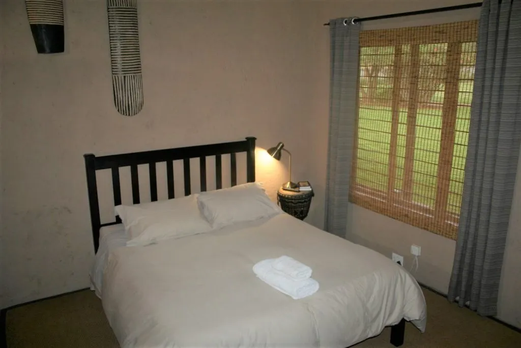 Neat bedroom with a bed window and bedside table with a lamp