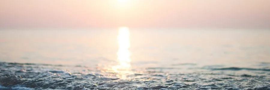 Sunset over the ocean with sunlight reflecting on the water