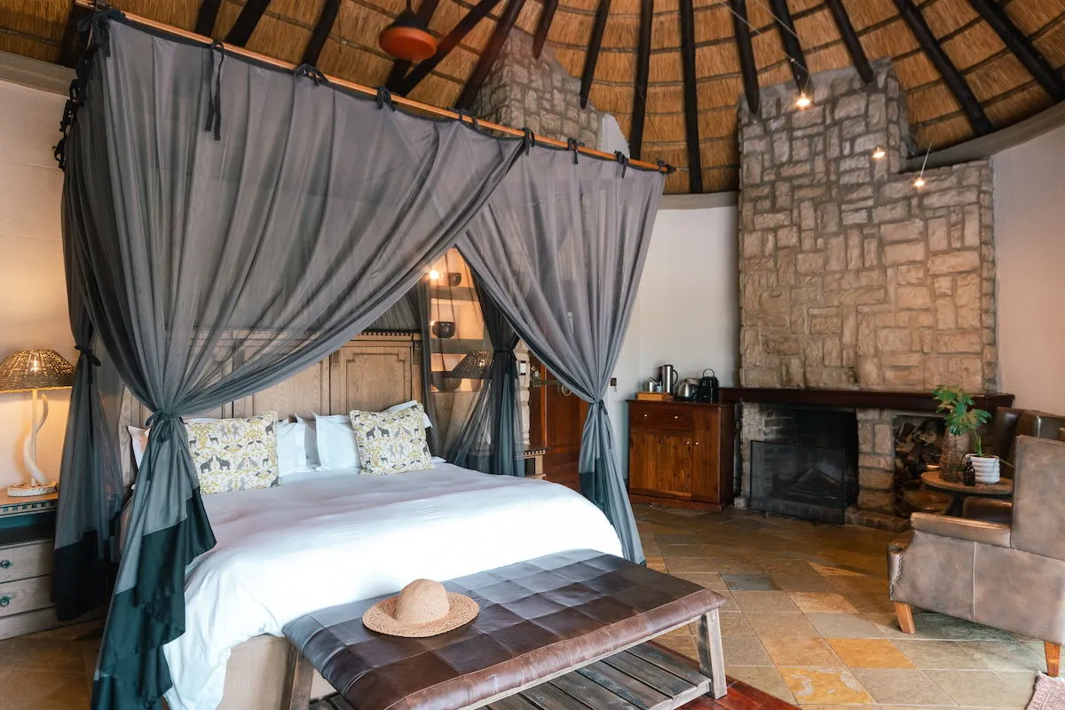 Cozy bedroom with a large bed fireplace and rustic decor