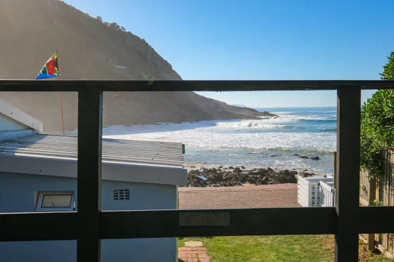 View of ocean from a balcony with a colorful flag on a hillside