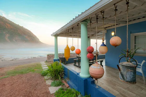 Beach house with colorful buoys hanging from the porch overlooking the ocean
